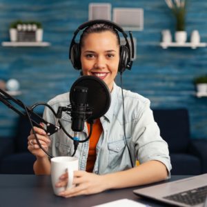 Influencer wearing headphones recording new podcast series at home studio for youtube channel